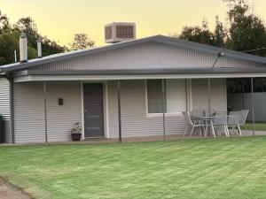 a white house with a table and chairs on it at Kangaroo Cottage in Hay