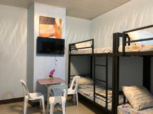 a room with a table and chairs and bunk beds at Ngs Suites in Sampong