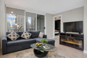 a living room with a couch and a tv at Modern Corner apartment in downtown in Vancouver
