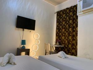 a hotel room with two beds and a tv at Ngs Suites in Sampong