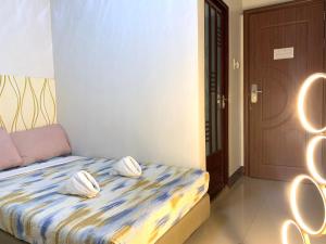 a bedroom with a bed with two pillows on it at Ngs Suites in Sampong