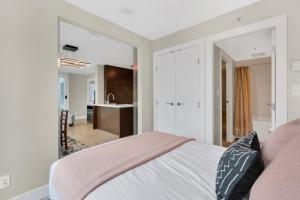 a bedroom with a bed and a bathroom with a sink at Modern Corner apartment in downtown in Vancouver