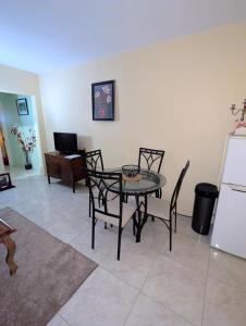 a dining room with a table and chairs and a refrigerator at Comsee Apartment Saint Mary in Highgate