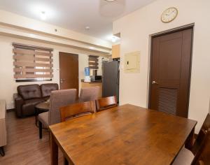 a kitchen and dining room with a wooden table and chairs at 2BR Cloud 512 with Parking Slot in Baguio