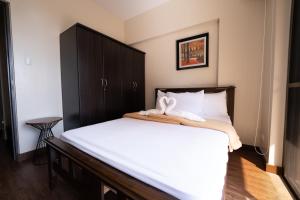 a bedroom with a large bed with white sheets at 2BR Cloud 512 with Parking Slot in Baguio