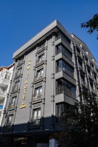 a building with a yellow sign on the side of it at Hamit Hotel Kizilay in Ankara