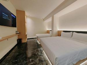 a hotel room with a bed and a tv at Hotel Classic in Malacca