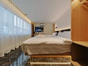 a bedroom with a large bed and a large window at Hotel Classic in Malacca