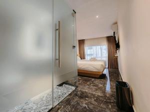 a bedroom with a bed and a glass door with a mirror at Hotel Classic in Malacca