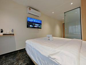 a bedroom with a white bed and a tv at Hotel Classic in Malacca