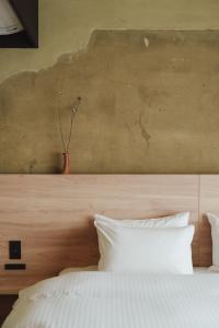a bedroom with a white bed and a vase on a wall at MUDANI 達磨町 Darumacho in Kyoto +18 photos