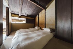 two beds in a small room with a window at MUDANI 達磨町 Darumacho in Kyoto