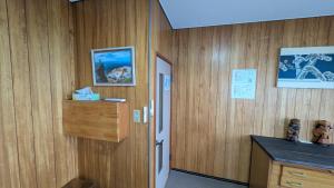 a room with wood paneled walls and a door with a counter at Tokachi Base Camp in Kami-furano