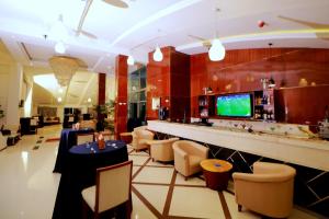 a restaurant with a bar with chairs and a television at Planet Hotel in Mekʼelē