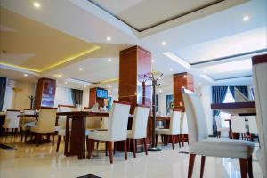 a dining room with white chairs and tables at Planet Hotel in Mekʼelē
