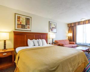 a hotel room with a bed and a chair at Quality Inn Dyersburg I-155 in Dyersburg