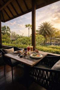 a table with food and drinks on a balcony at Lempuyang Boutique Hotel in Karangasem