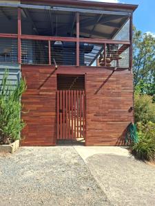 a wooden building with a gate in front of it at Cock or Two Kink House in Cockatoo