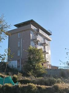 a tall building on top of a hill at Elite peak hotel in Kasauli