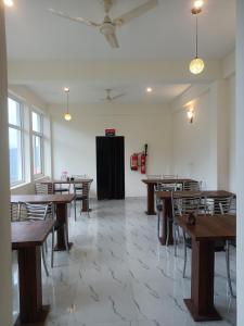 a dining room with wooden tables and chairs at Elite peak hotel in Kasauli