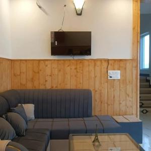 a living room with a couch and a flat screen tv at Elite peak hotel in Kasauli
