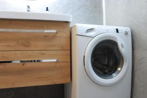 a washing machine in a bathroom next to a sink at Bled Castle View Apartment Medina in Zgornje Gorje