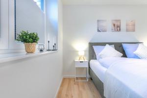 a bedroom with a bed and a table with a plant at Lütt Mööv - Seestraße 8 4 in Kellenhusen
