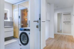 a kitchen with a washing machine in a room at Lütt Mööv - Seestraße 8 4 in Kellenhusen +23 photos