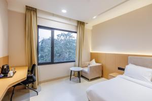 a hotel room with a bed and a desk and a window at Nirvana Nest - Corporate Stay, Gomti Nagar, Lucknow in Lucknow +54 photos
