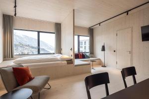 a bedroom with a bed and a large window at Me and All Hotel Flims, by Hyatt in Flims