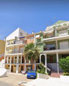 a building with a blue car parked in front of it at Casa Piszi in Torrevieja