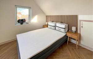 a bedroom with a large white bed with a window at Stunning Home In Sæby in Sæby