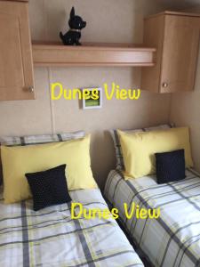 two beds sitting next to each other in a bedroom at Dunes Views in Prestatyn