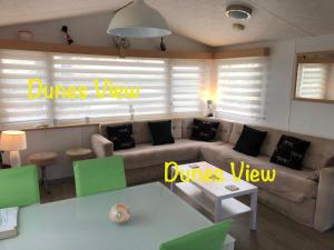 a living room with a couch and a table at Dunes Views in Prestatyn