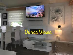 a living room with a television on a wall at Dunes Views in Prestatyn