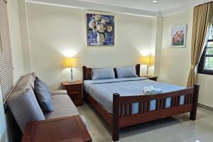 a bedroom with a bed and a couch at Kate House Bangsaphan in Bang Saphan