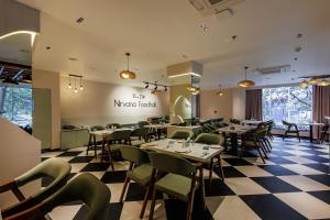 a restaurant with tables and chairs on a checkered floor at Nirvana Nest - Corporate Stay, Gomti Nagar, Lucknow in Lucknow