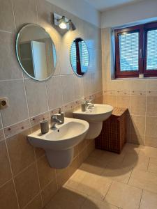 a bathroom with two sinks and two mirrors at Dům pod horami - Beskydy in Frýdlant nad Ostravicí +12 photos
