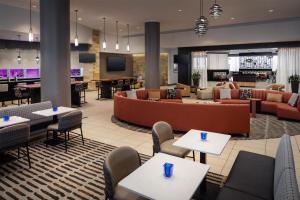a lobby of a hotel with tables and chairs at Hilton Albany in Albany
