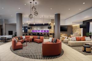 a lobby with couches and chairs and a bar at Hilton Albany in Albany