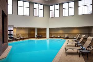a large swimming pool with chairs and tables at Hilton Albany in Albany