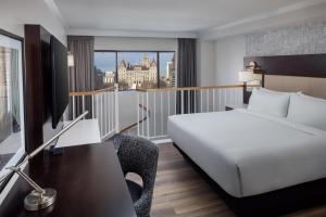 a hotel room with a bed and a desk and a window at Hilton Albany in Albany +39 photos