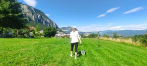 a woman standing in a field with a racket at Apartments Giovannini in Fai della Paganella +28 photos
