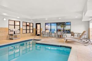 a pool in a hotel room with chairs and a table at Hampton Inn & Suites Detroit-Canton in Canton
