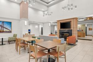 a dining room with tables and chairs and a fireplace at Hampton Inn & Suites Detroit-Canton in Canton