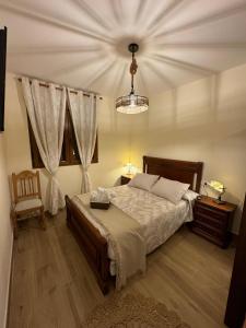 a bedroom with a bed and a chandelier at Los Abuelos Carreros in Consuegra
