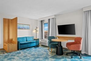 a hotel room with a blue couch and a table at Hampton Inn & Suites Detroit-Canton in Canton