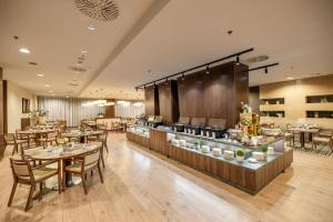 a restaurant with tables and chairs and a buffet at DoubleTree By Hilton Košice in Košice