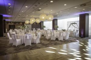 a banquet hall with white tables and chairs and chandeliers at DoubleTree By Hilton Košice in Košice