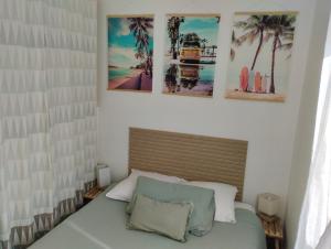 a bedroom with a bed with three pictures on the wall at Coté Lac mini in Mimizan
